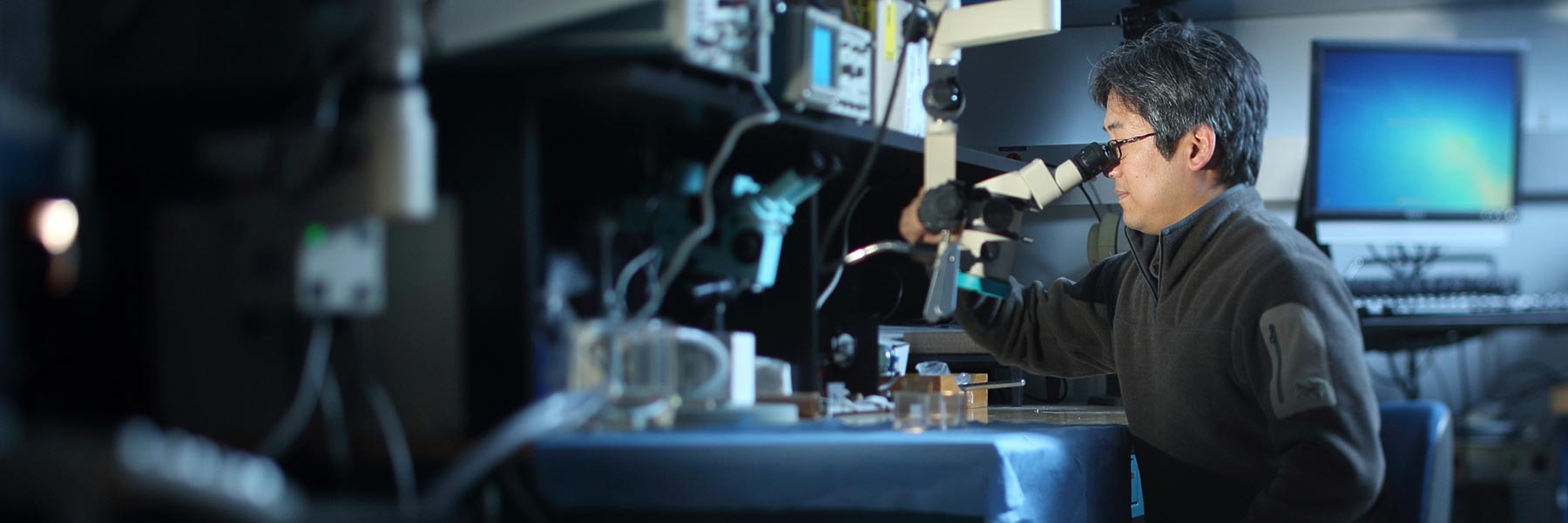 Ken Yoshida, an IUPUI School of Engineering and Technology professor, looks through a microscope.
